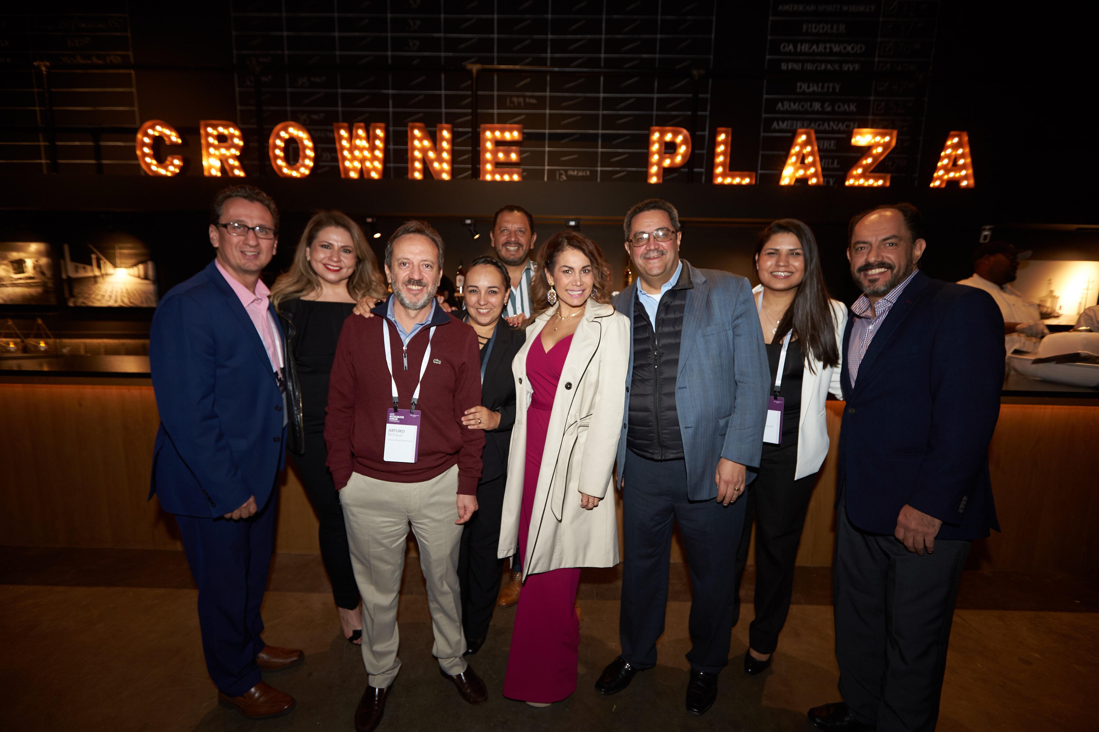 Picture of participants in front of Crowne Plaza marquee during corporate event. 